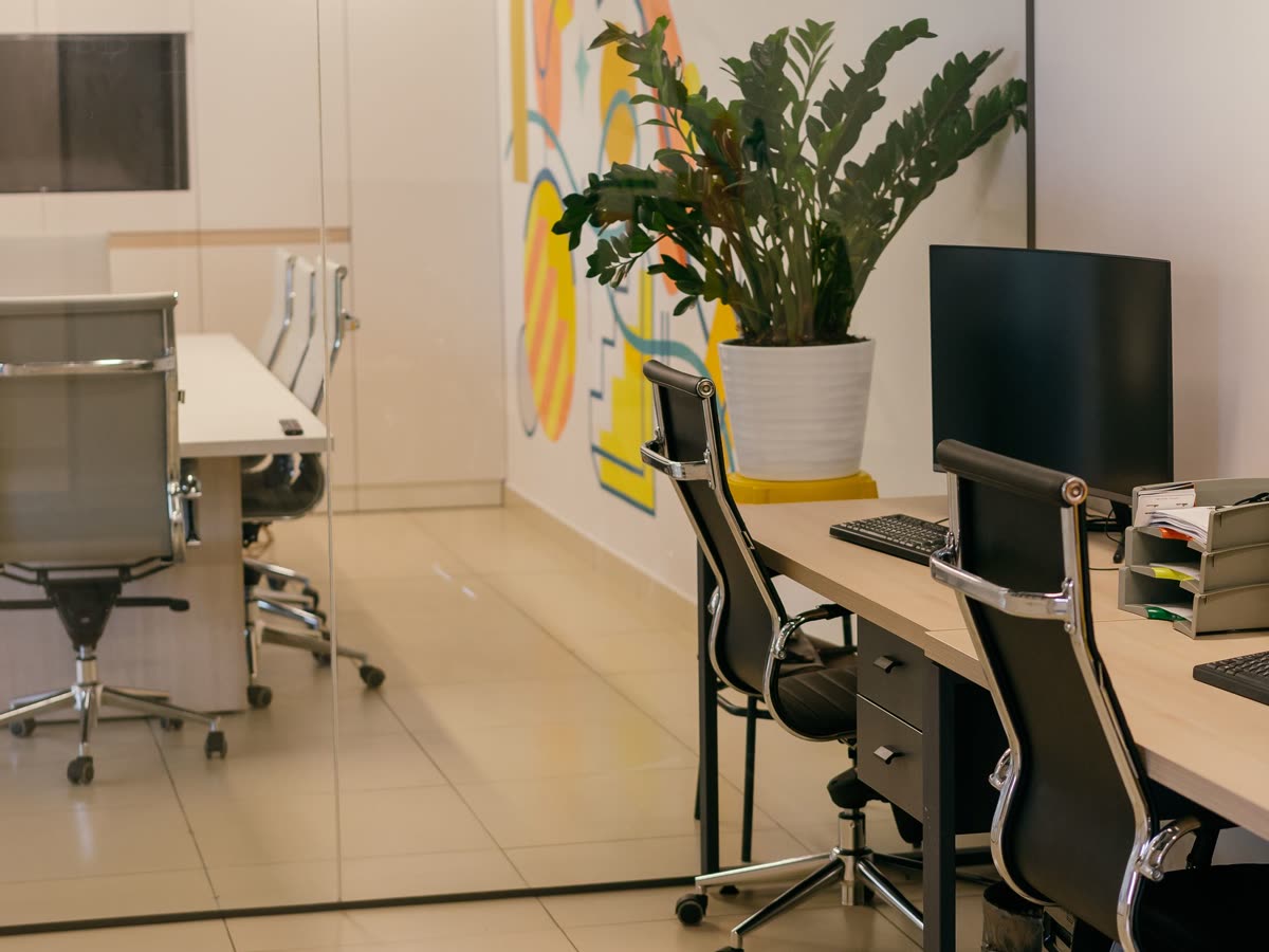 Ufficio moderno pulito con scrivanie e piante